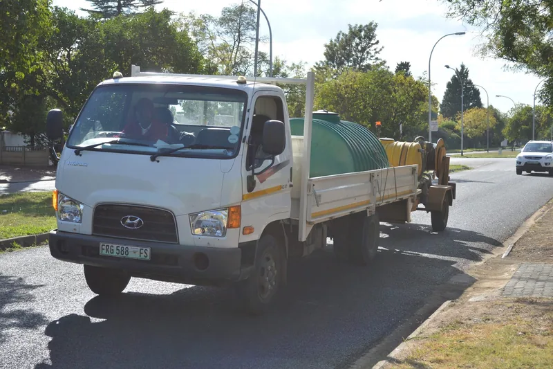 ARPCO's truck on a Bloemfontein street with a water tank on the deck, towing their high-pressure jetting trailer and hose reel